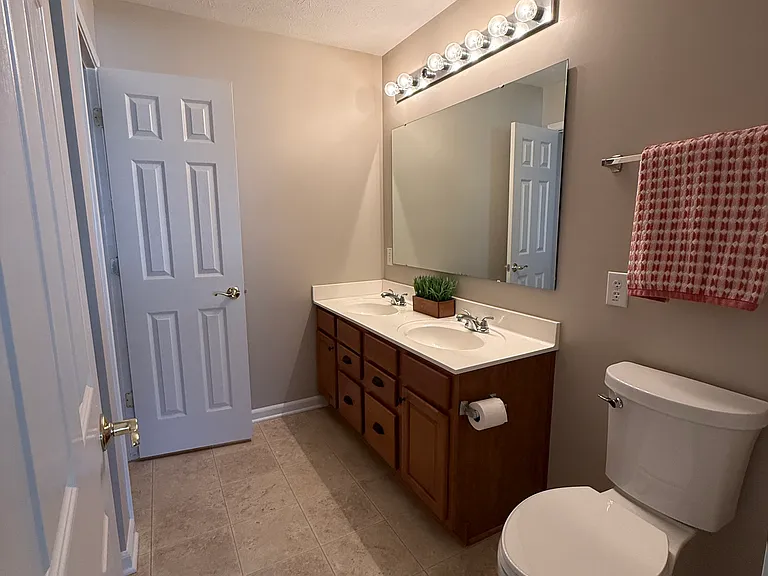Ensuite master bathroom with two sinks, linen closet and walk-in shower.