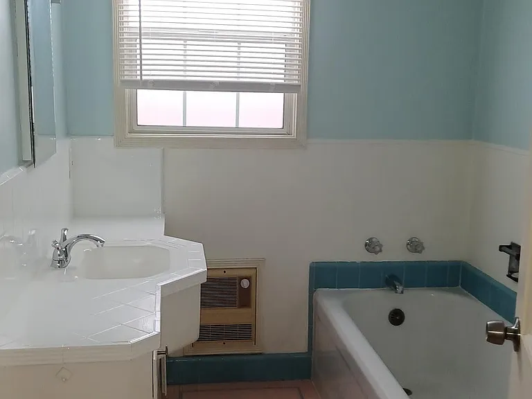 Bathroom view from entry door. Bath tub, vanity, separate shower.