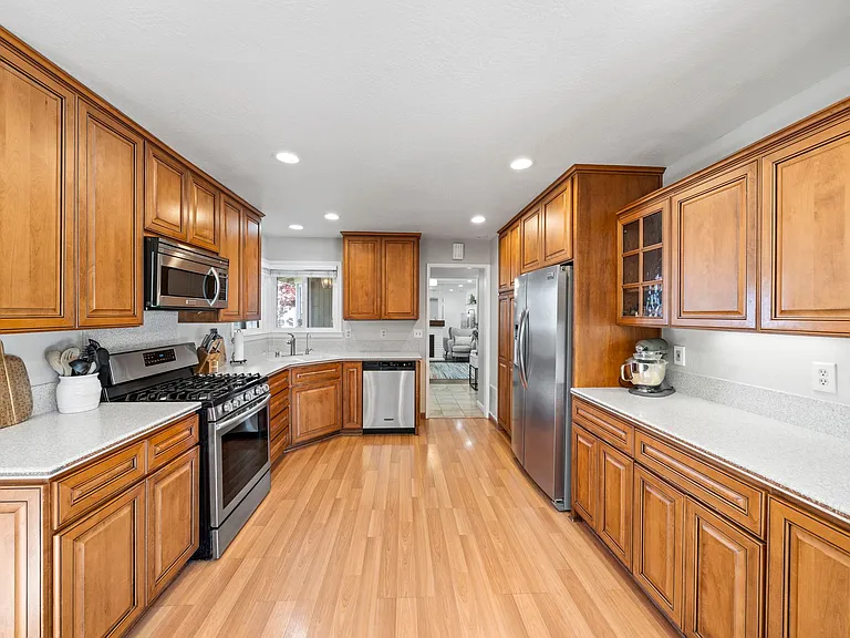 Kitchen with Corian counter top, Gas range, Oven, microwave, refrigerator, dishwasher & water purifier