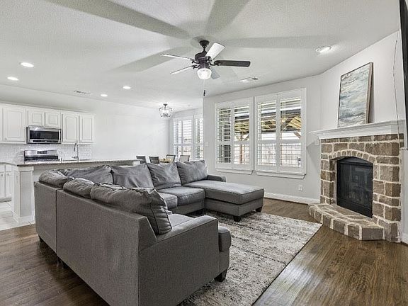 Living room with gas fireplace. Hardwood floors throughout.