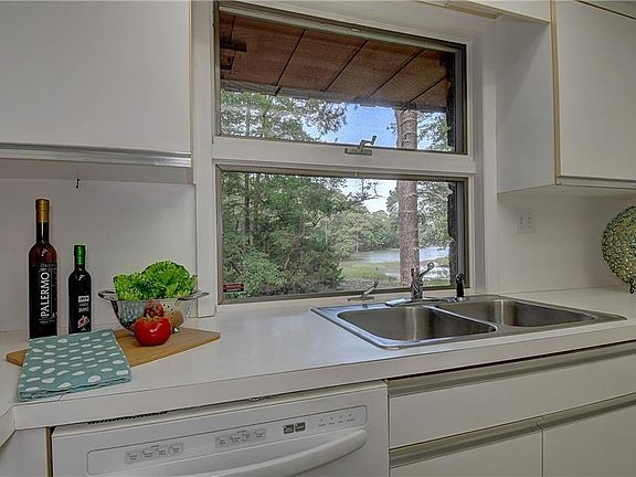 Great view of the water again from your kitchen workspace! Kitchen Aid Dishwasher conveys. stainless steel draw pulls. one continuous back splash from counter to upper cabinet.