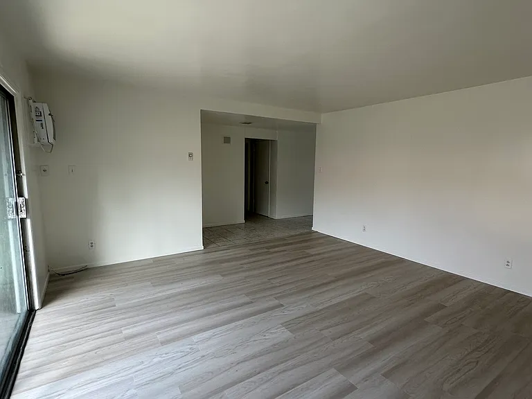 Living room with new laminate flooring and slider to the outside patio