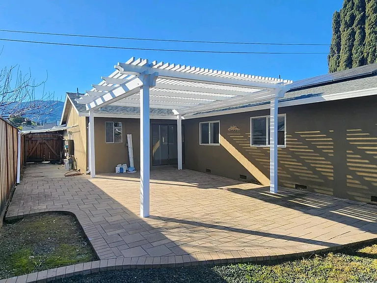 Side & Back yard with covered porch pergola and sliding glass door into kitchen.