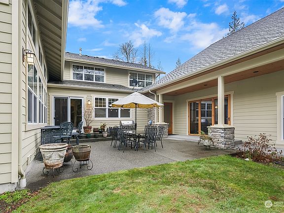 The large back patio area off of the kitchen & family room. Access the Spa Room to the right side through the Nana wall doors! Indoor / Outdoor living at its best. The covered walkway to the right leads to the outdoor kitchen area and great room. >