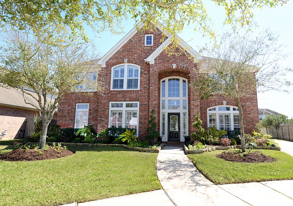 The front of the home with beautiful custom landscaping and sprinkler system.
