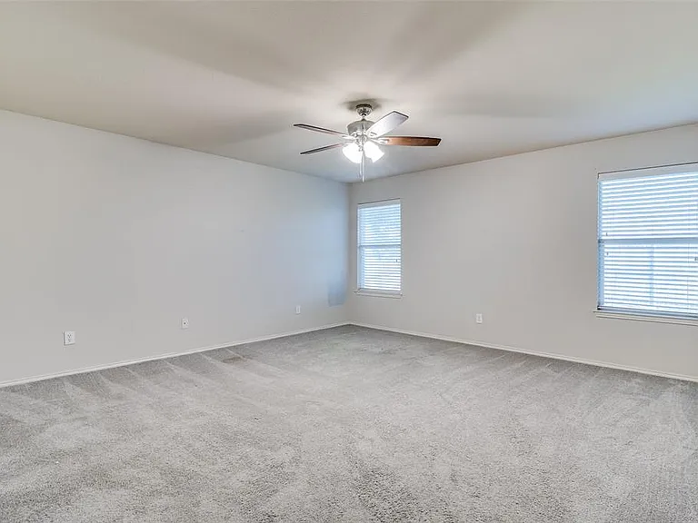 Carpeted empty room with ceiling fan