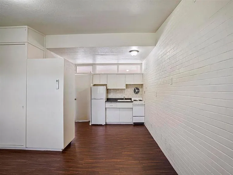 Kitchen and living room with a white brick wall.