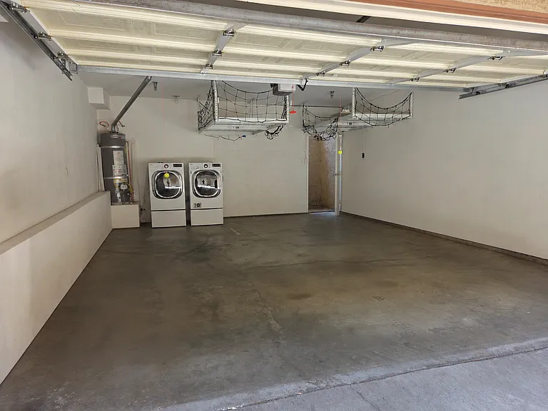 Spacious private 2-car garage with plenty of storage space including storage racks. Includes full washer and dryer.