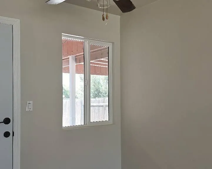 Bright room with a ceiling fan, fresh paint, and natural light.
