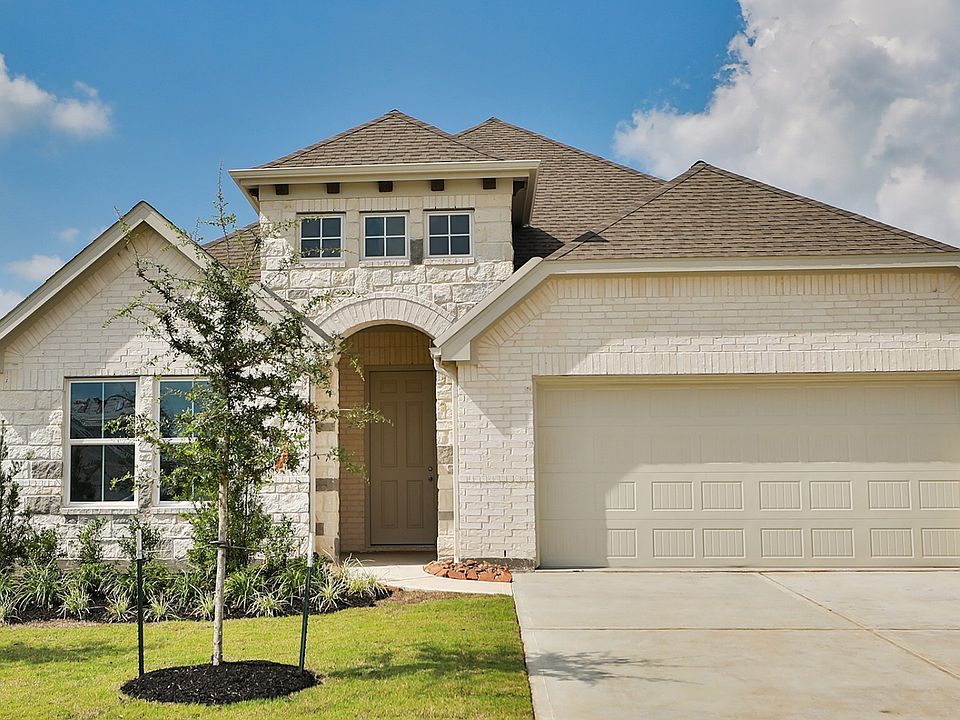 Elegant brick facade and arched entry define this Westland Ranch home. Meticulously landscaped front