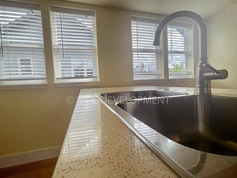 Kitchen view facing South with Unit A in background. Lots of natural light with many windows throughout.