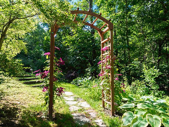 The entryway wind through a lovely. lush, garden path