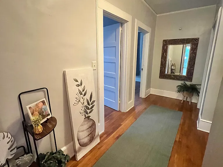 wide hallway connects bedrooms to downstairs bath
