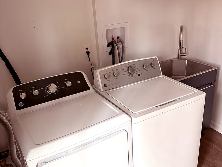 New washer, dryer and utility sink with cabinets for storage. 1/2 bath is in this room. Backdoor located in this room as well. Roughly 9x11