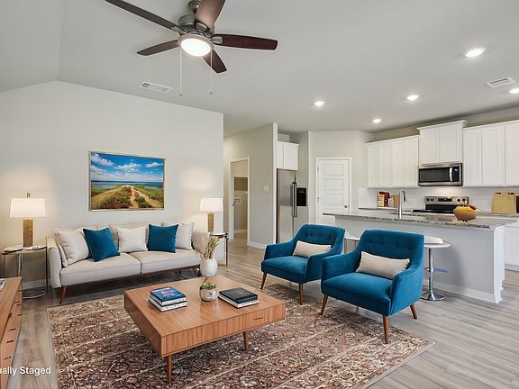 Virtually staged living room and kitchen the Callaghan floorplan at a Meritage Homes community.