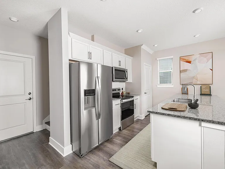 A bright, streamlined kitchen at Amavi Kissimmee features stainless steel appliances and generous counter space, creating a clean, inviting place to start and end each day.