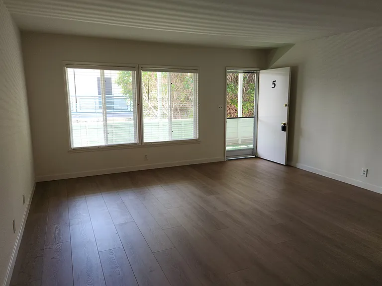 Spacious Livingroom with large windows and laminate floors
