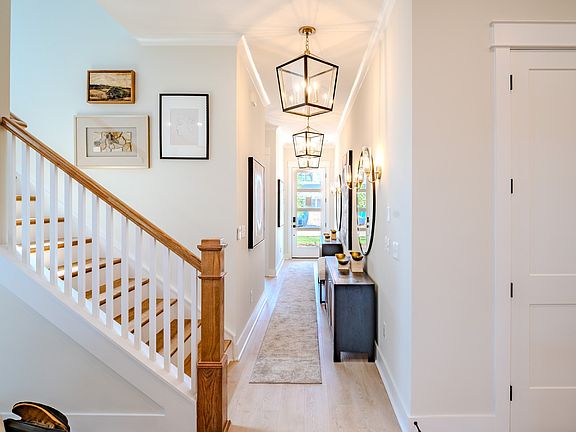 Entryway facing the front door with pendant lighting and access to staircase