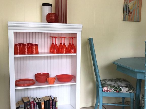Dishes and book shelf for storage in dining area. Some books to read, too!