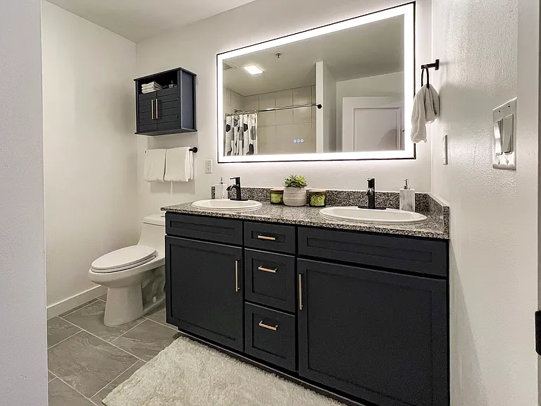 Remodeled bathroom with massive self defogging and dimmable mirror.