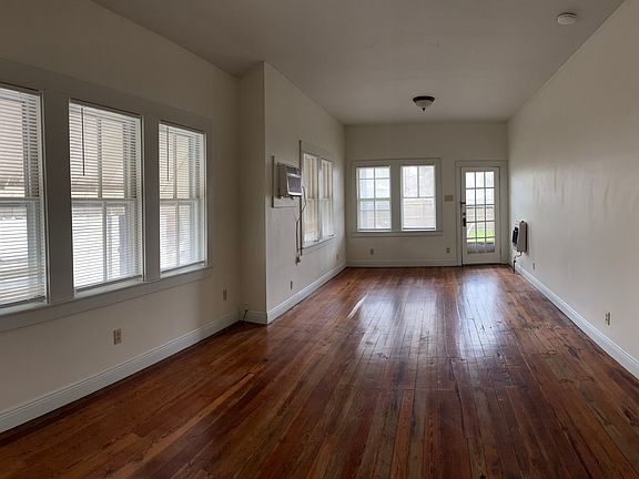 Combined living/bedroom area with hardwood floors and lots of natural light