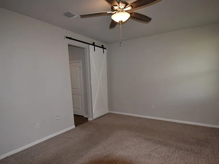 Primary bedroom with barn door to the primary bathroom