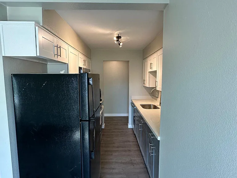 Kitchen with new quartz countertop and cabinets. Dishwasher, stove range, microwave, and big size refrigerator
