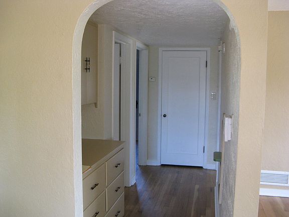 hallway to bathroom and two bedrooms; storage in hallway and vintage phone center