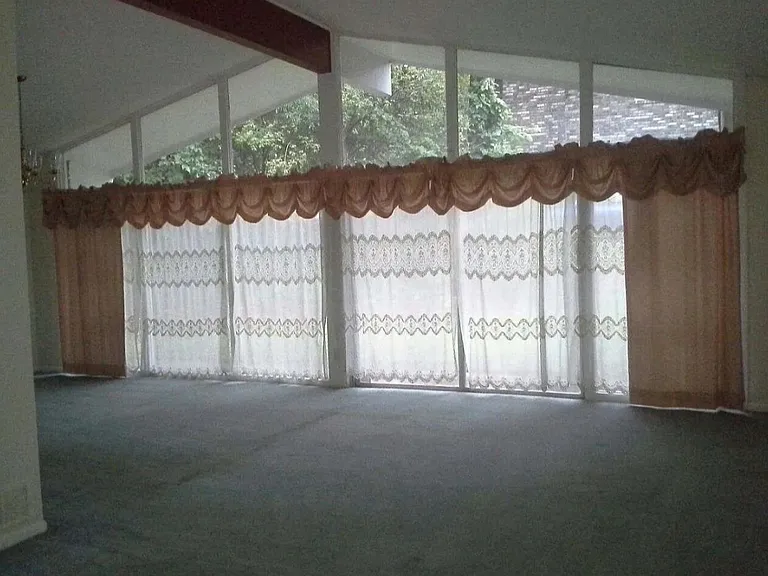 Spacious living room with a formal dining room combined. Gorgeous complete wall of glass windows allowing bright lighting to filter through