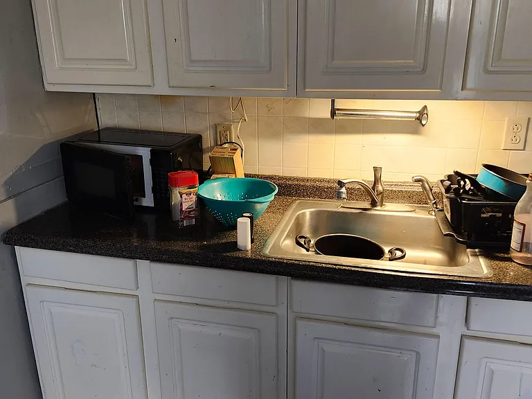 Kitchen counter area with ample cabinetry, laminate countertops, tile backsplash, and a double-basin sink.