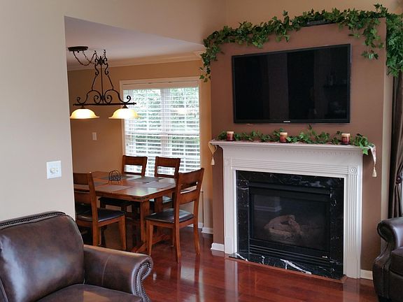 Marble accented, natural gas fireplace central to main living space is remote controlled.