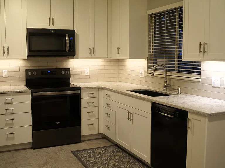 Dimmable LED under cabinet lights. White faux wood window blinds & LVP flooring.