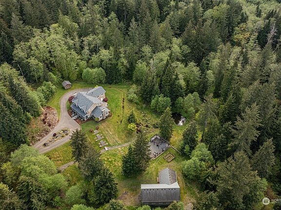 Nestled on 6.9 acres of privacy and tranquility, this expansive property includes its 3,970 sf home, a 2,800 sf shop building with additional office or living quarters, a large outdoor kitchen and entertaining area, a gardening area with raised beds, a small duck pond, and roughly 5 forested acres of elk trails to explore.>