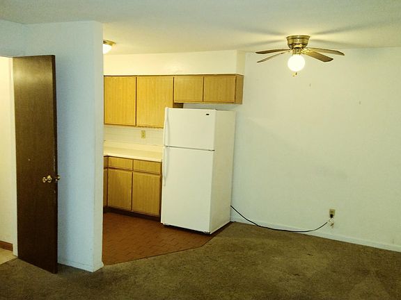 View from the living room into the kitchen. The door on the left is the half bath.