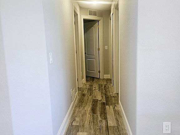 The hallway leads to three spacious bedrooms, each thoughtfully designed to provide comfort and privacy for the whole family.