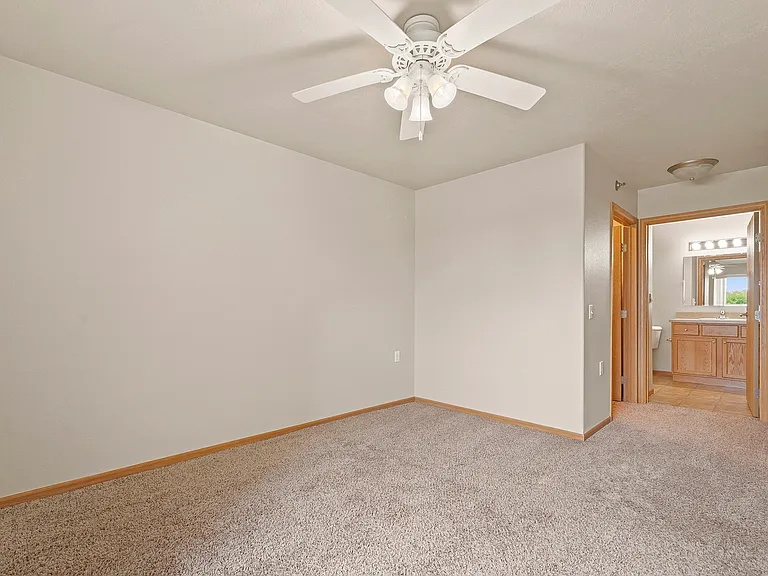 Embrace the comfort of Northdale Apartments with this spacious living area, featuring plush carpeting and a ceiling fan for optimal airflow. Tailored for relaxation, it offers a perfect canvas to create your ideal home. Schedule your visit today!
