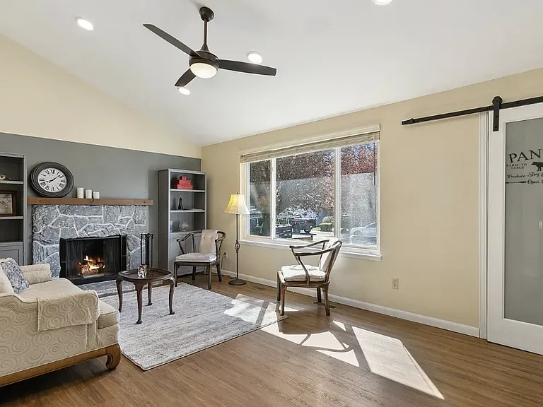 Living room with vaulted ceiling and wood-burning fireplace.