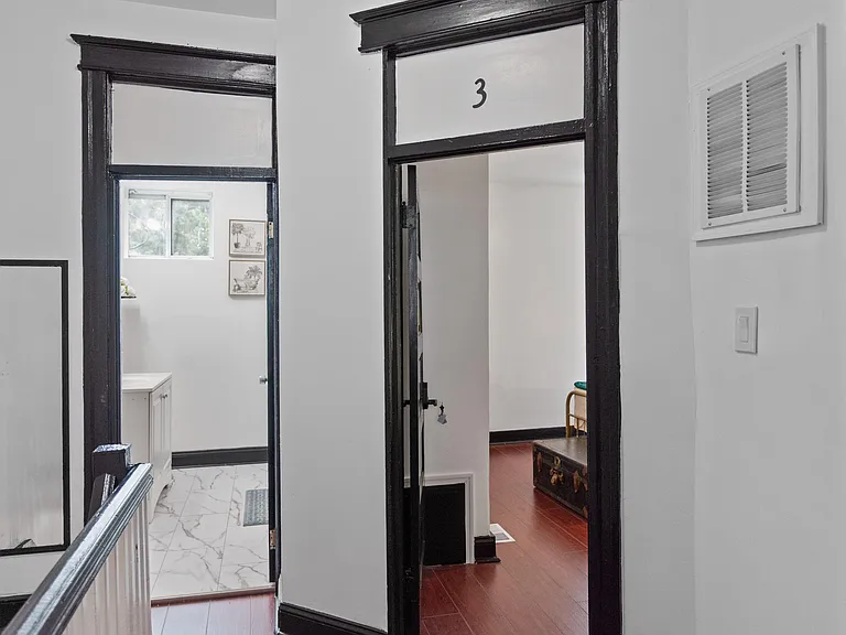 Upstairs hallway with classic trim and easy access to adjacent rooms, plus a window for natural light.