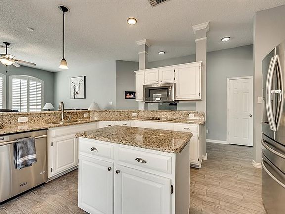 Gorgeous updated kitchen features Stainless Steel appliances, white cabinets and brushed nickel hardware.