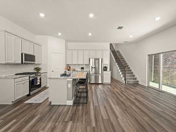 Kitchen opens to living area and dining area with access to back yard