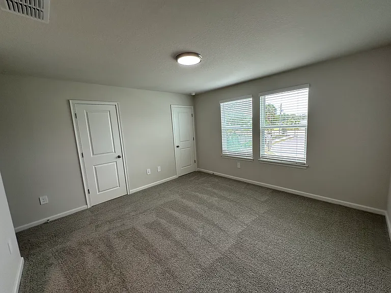 Primary Bedroom Featuring Two Walk-In Closets