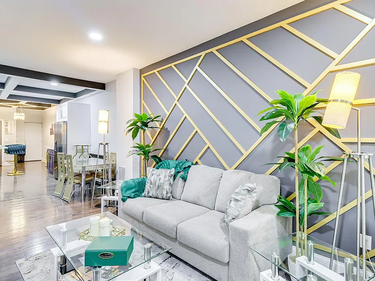 Open living area with contemporary accent wall, comfortable seating, and easy flow to the dining space and kitchen.