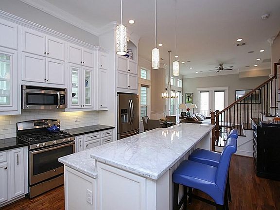 The kitchen also features stainless appliances, built-in microwave, pendant lighting and notice the glass cabinet doors for displaying your favorite pieces.