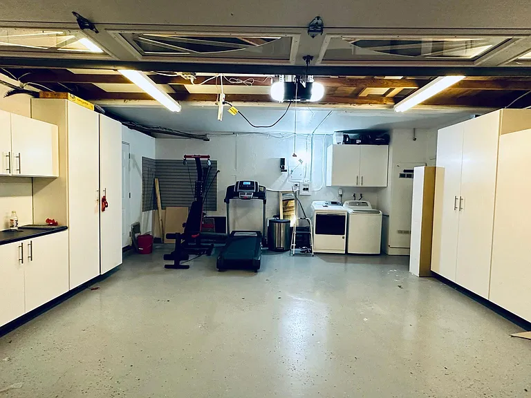 Garage with custom cabinets and gym equipment