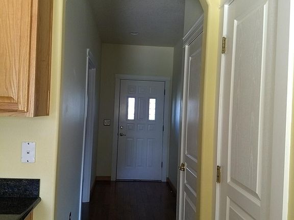 Hallway to 2 bedrooms, bathroom and Front door, with hardwood flooring and lots of closet space.