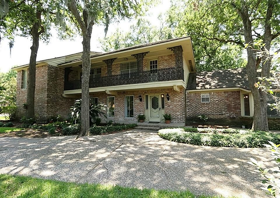 Lovely New Orleans style home on heavily wooded lot with beautiful wrought iron balcony.