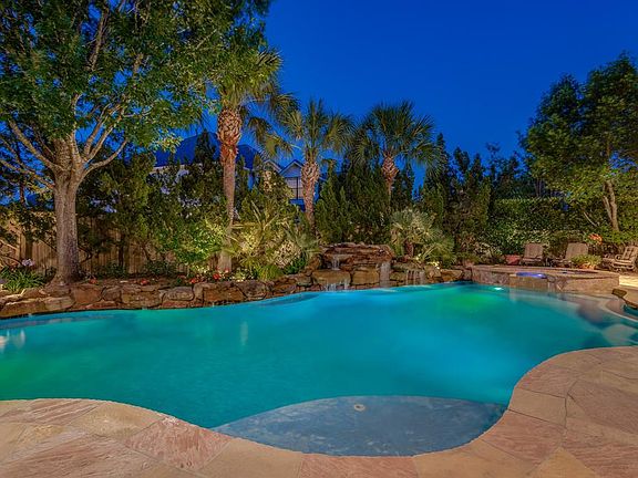 WITH MULTIPLE ENTERTAINING AREAS, THE ROCK WATERFALLS IN THE BACKGROUND AND THE TROPICAL LANDSCAPING, YOUR BACKYARD BECOMES A YEAR ROUND LIVING AREA.