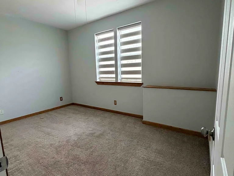 Bedroom from hallway, plenty of natural light, shades drawn