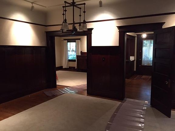 Living room leads to formal dining on left, hallway to bedrooms on right
