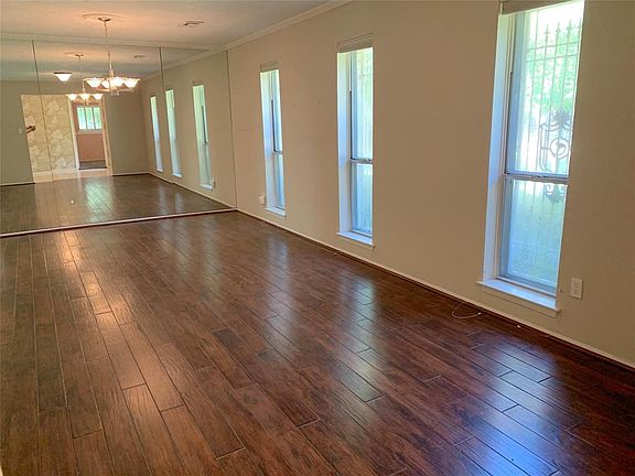 View of formal living room and dining room with lots of windows and engineered wood floors. Light and bright!